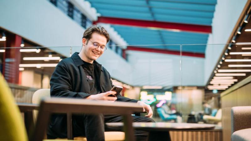 student sitting lookin at mobile phone